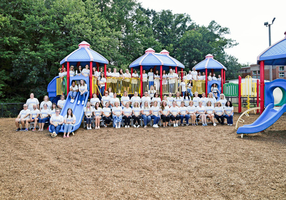 Fairview staff posing for staff photo on playground equipment