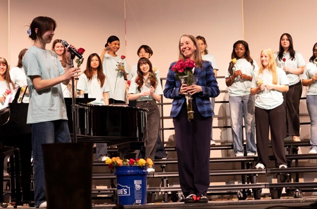 Teacher and students standing on a stage