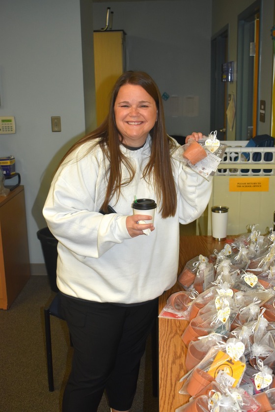 A picture of Mrs. Workman receiving her gift card and desk plant