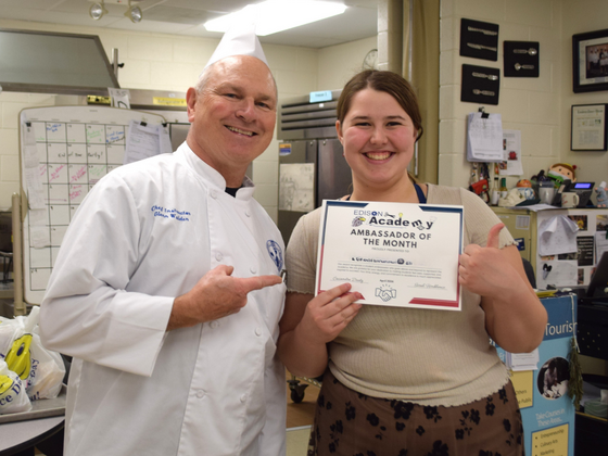 student winner holding the award certificate posed with their teacher
