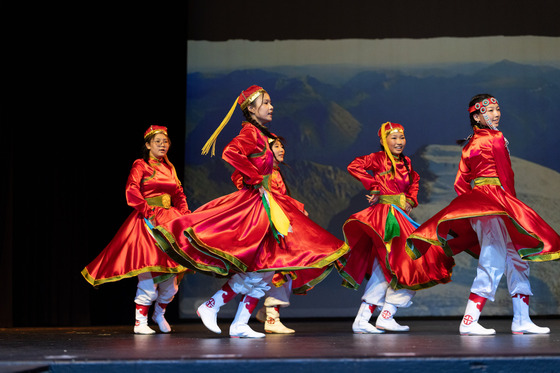 Students in traditional dress dancing on stage
