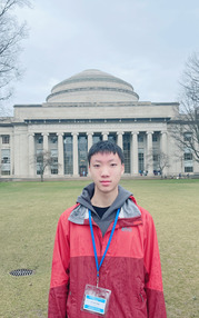 Student Ethan Ma wears a lanyard and poses in front of a government building