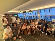 Group of students in a modern lounge with large windows.