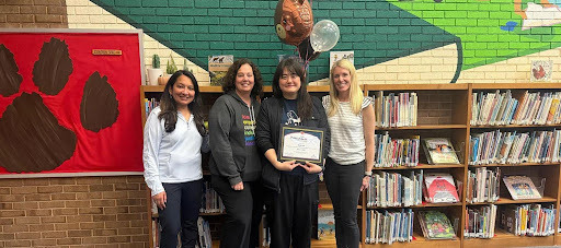 Teacher receives and award in a library