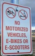Sign on metal post stating no motorized vehicles, e-bikes or e-scooters