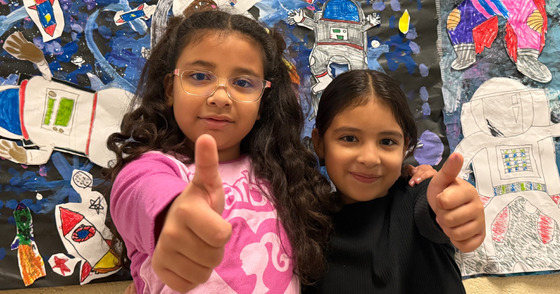 Two students giving a thumbs up