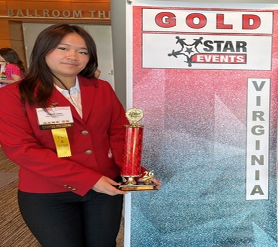Student standing and holding trophy