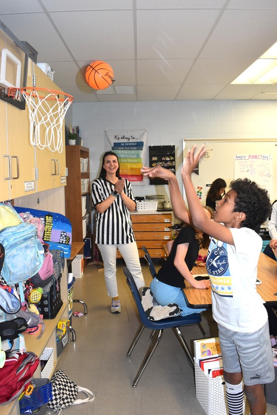 A student preparing for their math SOL test with a classroom basketball game