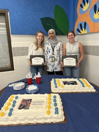 3 staff members standing behind 2 cakes