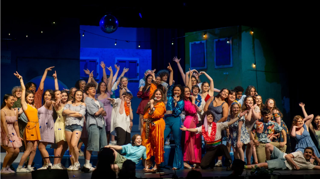 students posing on stage during performance of Mamma Mia