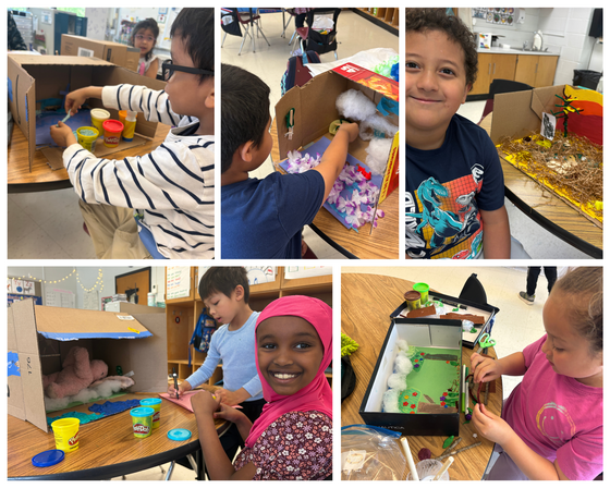 First graders building animal habitat dioramas using cardboard boxes, Play-Doh, and craft supplies in a diverse classroom setting.