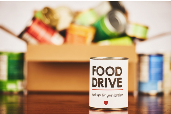 collection of food with a can in the foreground that says "food drive"