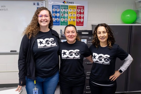three employees smile for a photo