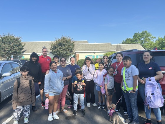 Students at bus stop with Principal Gerstner and Parent Liaison Ms. Chavez.