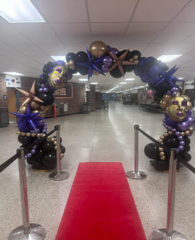 balloon arch framing a red carpet