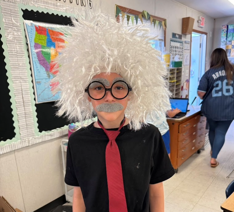 a student dressed up with wacky hair, mustache, and big puffy eye brows