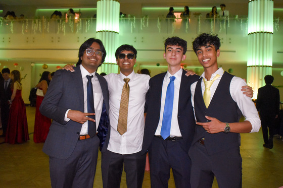 Four TJ Seniors Smile for camera in their suits at the senior prom.