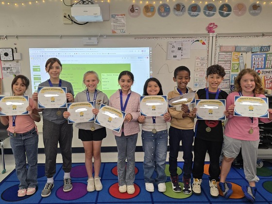 A group of 8 students from 3rd grade holding their Perfect Attendance certificates.