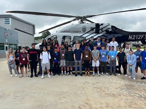 Young people stand by a Fairfax County police helicopter