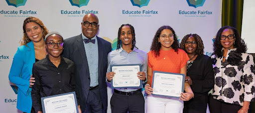 Three students hold awards and four adults smile with them. 