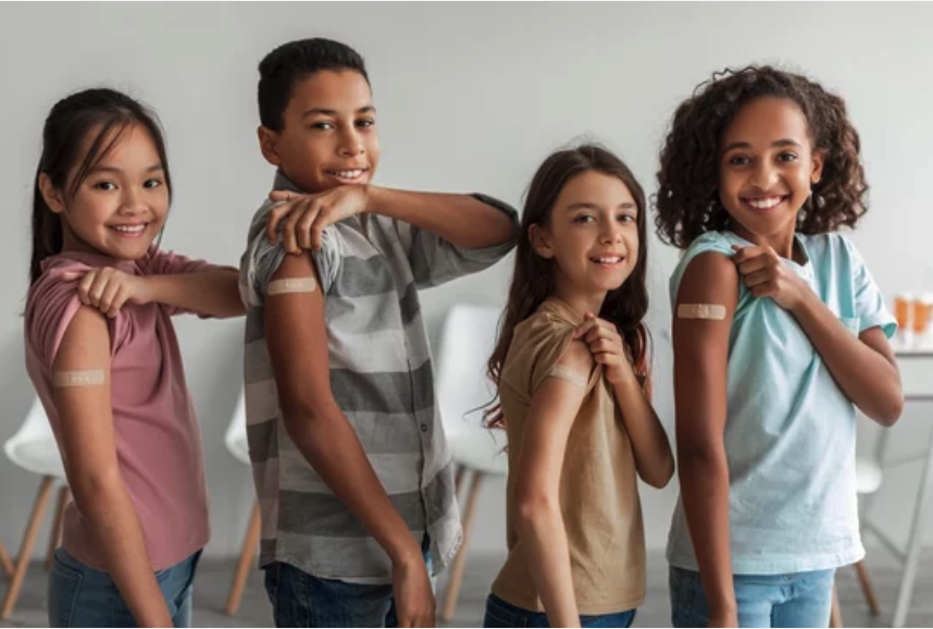 Four students showing bandages on their arms from immunizations