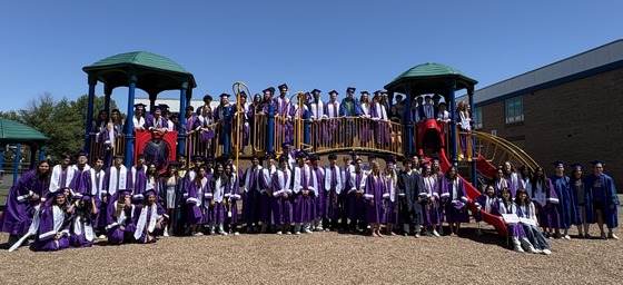 Students in graduation regalia on the Oak Hill playground