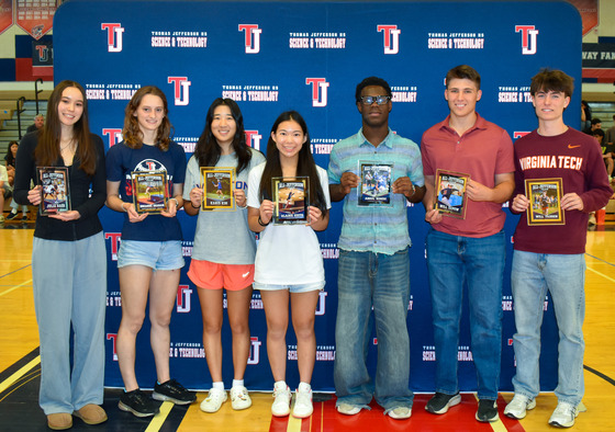 7 of the 8 All-Jefferson Team members posing in front of the TJ Athletics backdrop with their plaques.