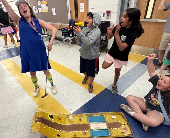 A teacher and students excited because she made a hole in one