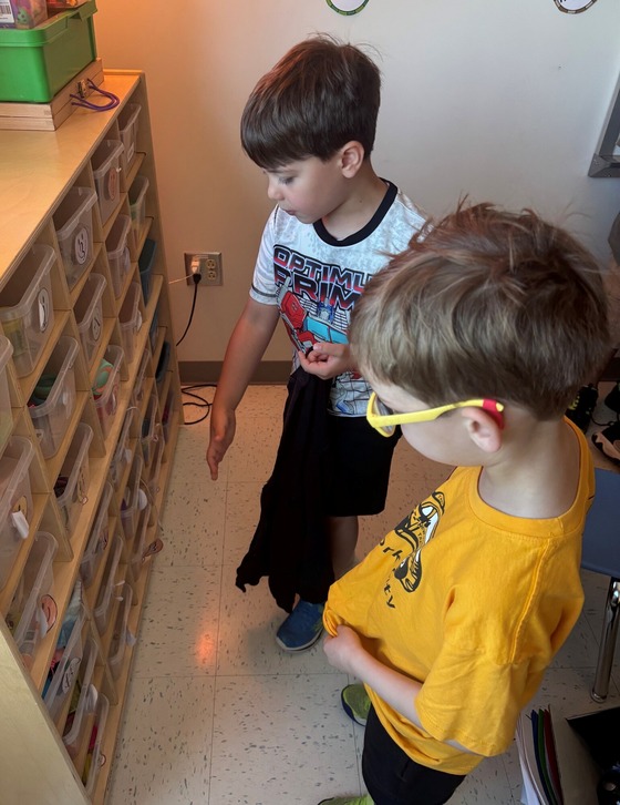 a student explaining to another student about the learning bins