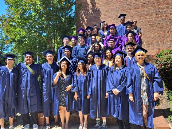 Students in Caps and gowns on steps outside