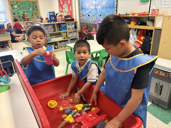 Niños jugando con agua en la clase preescolar