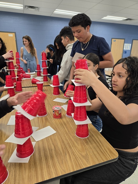 Students playing a game stacking cups at a celebration