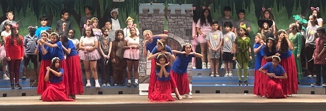chorus students performing wearing colorful costumes