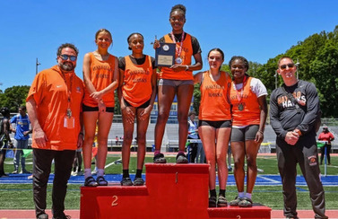 group of students in track uniforms on football field
