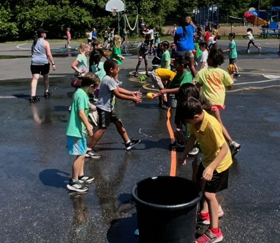 Students playing catch with water balloons