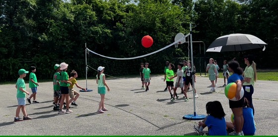 Students playing volleyball with an oversized beach ball