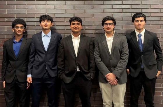 TJ Math Modeling Team posed in line against brick wall