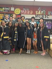 students in graduation robes standing on staircase