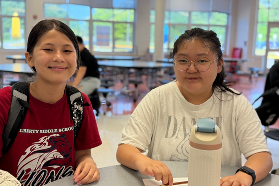two students smiling at a table