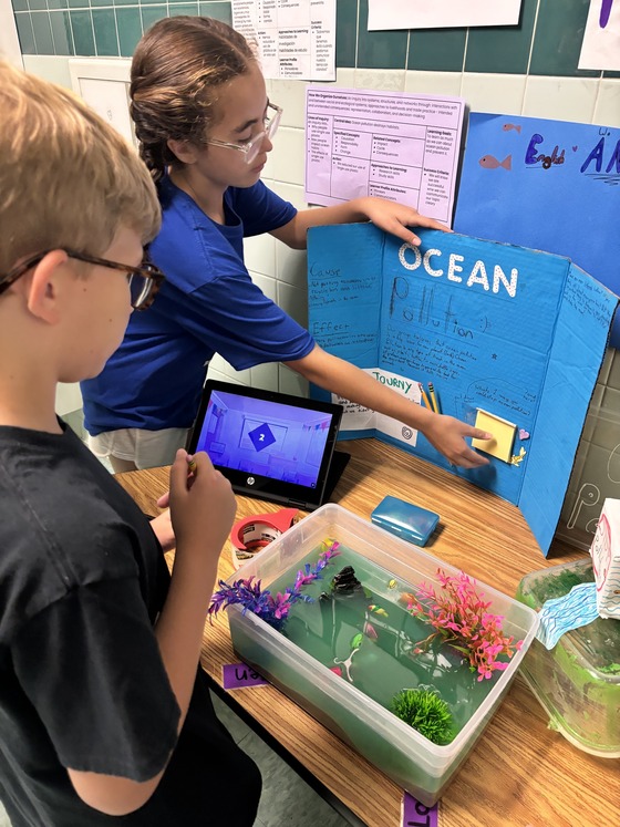5th Grade student showing her PYPX project about Ocean Pollution