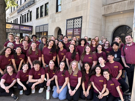 Students wearing the same shirt posing in front of the National Theater