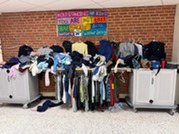 picture of lost and found items - lots of sweatshirts and lunchboxes
