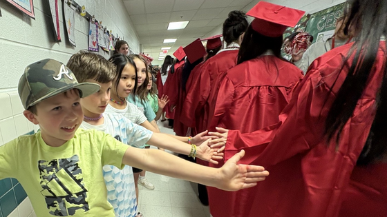 young child high fiving graduate