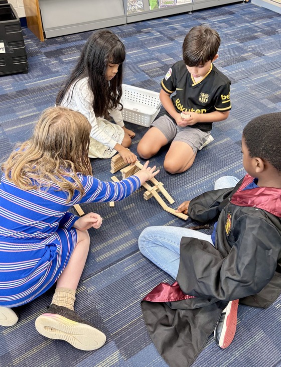 Older students were paired with younger students to use wooden Keva plants to build a ramp for a ping pong ball.