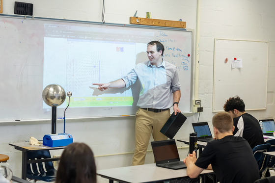 An image Mr. Sean Jones standing at the front of a classroom pointing at the whiteboard