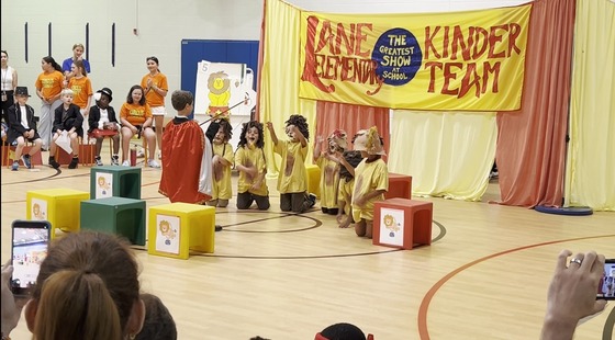 Students dressed as lions and a lion tamer performing in the Kindergarten Circus