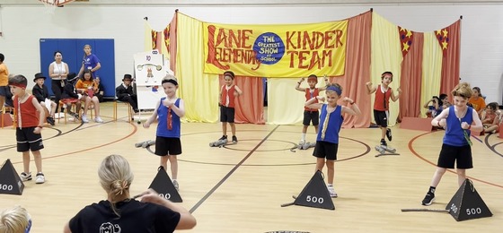 Students dressed as weight lifters performing in the Kindergarten Circus