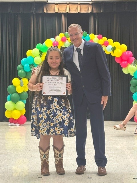 Mr. Gerstner awarding Rosa Alvarado Rodriguez the 2026 Principal's Award during the 6th grade promotion ceremony.