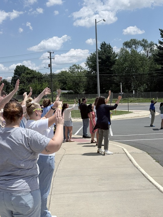 Teachers waving goodbye to buses