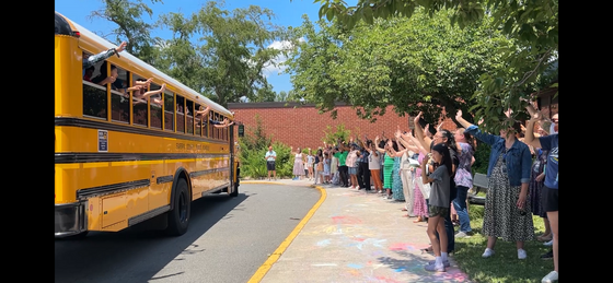 teachers waving to students on the bus